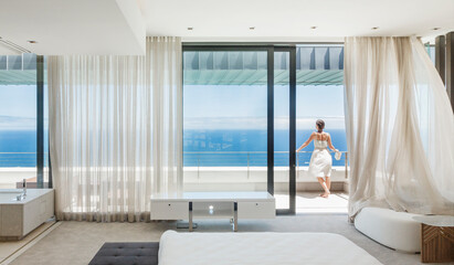 Fototapeta na wymiar Woman on modern balcony overlooking ocean