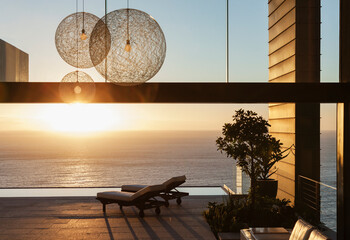 Patio of modern house overlooking ocean at sunset