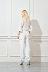 Back view of a woman in white shirt and trousers