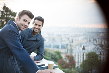 Businessmen smiling at railing overlooking Paris, France