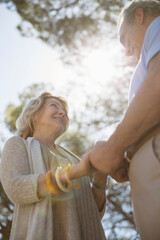 Fototapeta premium Senior couple holding hands under trees