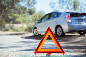 Car at roadside behind warning triangle