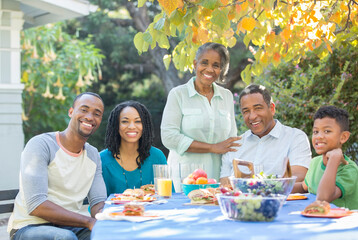 Portrait of smiling multi-generation family eating lunch on patio