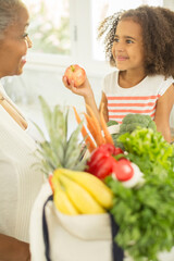 Grandmother and granddaughter unpacking groceries