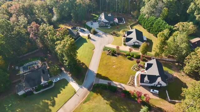 Aerial view of new family houses between yellow trees in South Carolina suburban area in fall season. Real estate development in american suburbs