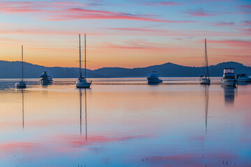 Fototapeta na wymiar Beautiful sunrise waterscape with high cloud, reflections and boats