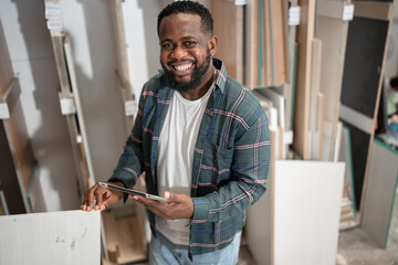 Portrait African American carpenter use paper work with wood sheet at wood factory