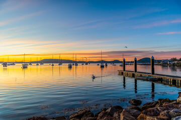 Obraz premium Beautiful sunrise with high cloud and boats on the water