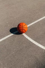 Fotobehang Basketball ball on outdoor court with asphalt surface © Bits and Splits