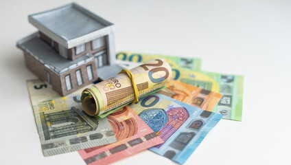 little house model with many dollar banknotes and keys. Real estate insurance. Investment
