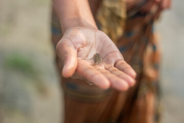 A young man holds a fish and its background blur