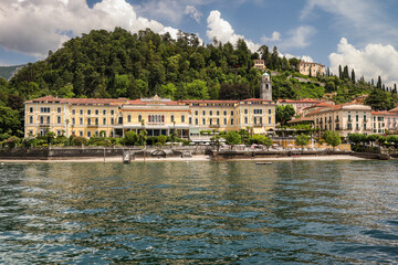 Fototapeta na wymiar Bellagio Town in Italy with its Beautiful Architectural Buildings. Lake Como in Lombardy with Hilly Forest during Summer Travel Day.