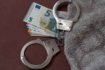 Handcuffs - photo on money banknotes. Metal handcuffs are laying on money banknotes. Dollars and...