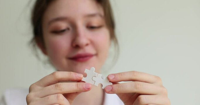 Connecting jigsaw puzzle business solution woman connects jigsaw puzzle. Success and strategy concept connecting pair of puzzle pieces