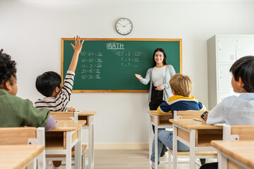 Group of student learn with teacher in classroom at elementary school.