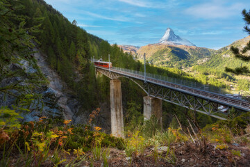 Zermatt, Switzerland. Gornergrat red tourist train on the bridge and Matterhorn peak panorama in...