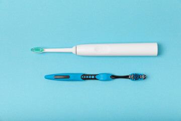 Electric and manual toothbrushes on a blue background. View from above. Oral hygiene. Ordinary toothbrush, eco and electric toothbrush. Oral hygiene. Oral Care Kit. Dentist concept. Dental care. 