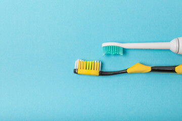 Electric and manual toothbrushes on a blue background. View from above. Oral hygiene. Ordinary toothbrush, eco and electric toothbrush. Oral hygiene. Oral Care Kit. Dentist concept. Dental care. 