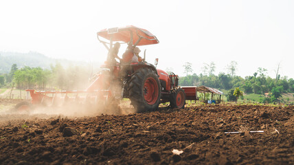 Fototapeta premium Farmer in tractor preparing land with seedbed cultivator as part of pre seeding activities in early spring season of agricultural works at farmlands Cultivated field Agronomy farming husbandry concept