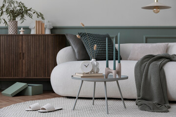 Cozy living room interior with boucle sofa, round coffee table, stylish sideboard, green pillows,...