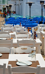 Colorful tables and chairs of Greek outdoor cafes and restaurants in