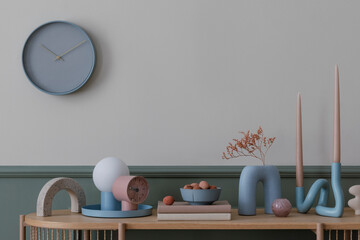 Fototapeta na wymiar Warm composition of cozy living room interior with wooden sideboard, vase with dried flowers, books, blue lamp, clock, stylish sculpture and personal accessories. Home decor. Template.