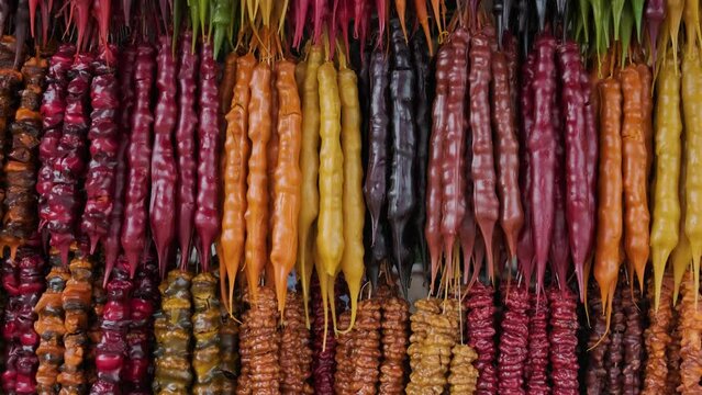 Churchkhela. Traditional Georgian cuisine candle shaped candy sweets with hazelnuts, walnuts, grape juice, honey in local market