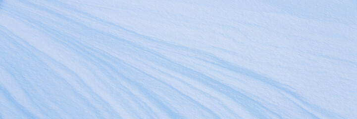 Beautiful winter background with snowy ground. Natural snow texture. Wind sculpted patterns on snow...