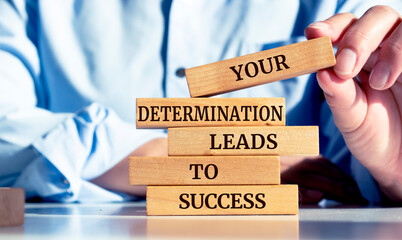 Close up on businessman holding a wooden block with a "Your determination leads to success" message