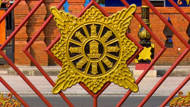Surya Majapahit is a symbol commonly found in ruins dating from the Majapahit era. Remade from iron and then painted yellow gold attached to the guardrail of a highway in Mojokerto, Indonesia.