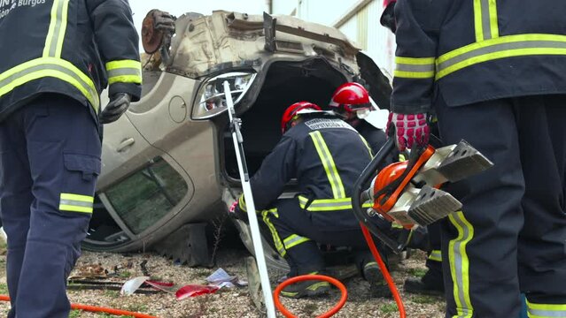 Firefighters using hydraulic tools during a rescue operation training. Rescuers unlock the passenger in car after accident. High quality 4k footage