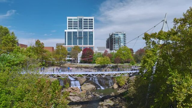 Aerial view of Reedy River Waterfalls in downtown of Greenville city in South Carolina. Falls Park riverwalk at Liberty bridge. American travel destination