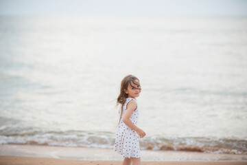Fototapeta na wymiar child girl runs to sea in evening. gentle soft portrait