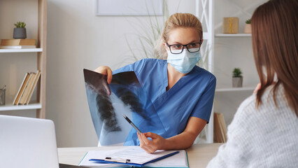 Chest radiology. X-ray diagnostic. Woman doctor examining lung film scan at radiology department in...
