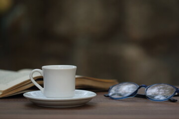Cup of coffee on the table. Reading a book concept. 