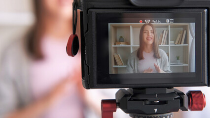 Online influencer. Live streaming. Woman blogger creating content shooting video for social media vlog using camera communicating with subscribers at home.