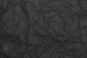Black wrinkled paper texture. Grunge dark background