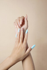 Woman hands with trendy manicure on brown background 