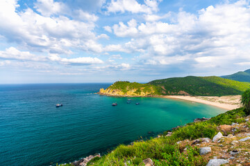 Beautiful bay on a sunny day with white sand beach, mountains and clear blue sea, a favorite ecotourism place in Vietnam
