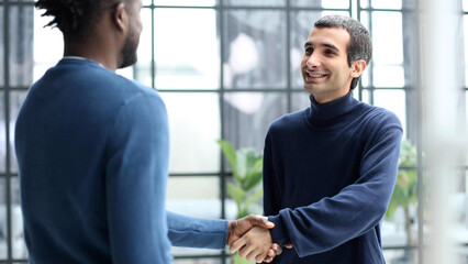 Fototapeta na wymiar Headshot portrait of a smiling businessman offering a handshake. Business concept