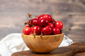 Cherry in bowl. Organic farm products. Fresh cherry on wooden background
