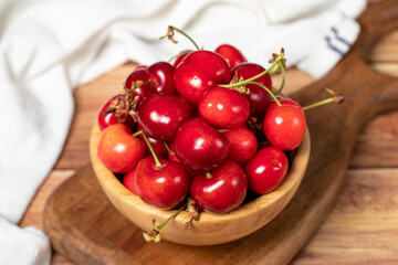 Cherry in bowl. Organic farm products. Fresh cherry on wooden background. Close up