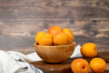 Apricot in bowl. Organic farm products. Fresh apricots on wooden background