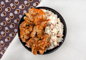 Traditional South African Peri Peri chicken livers with samp and beans on traditional South African fabric with copy space