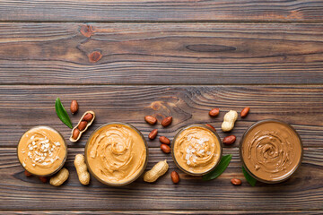 Glass jar with peanut butter on table background, top view space for text and close up