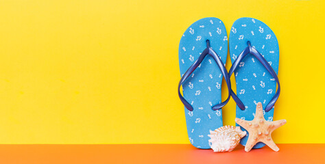 Beach accessories. Flip flops and starfish on colored background. Mock up with copy space