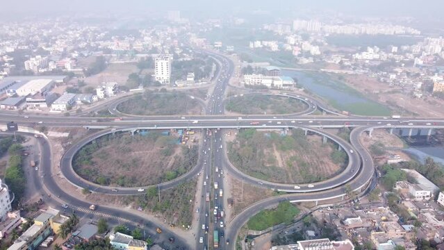 Drone shot of Iconic cloverleaf interchange of Maduravoyal flyover bridge drone under smoggy and hazy morning with smooth flowing traffic, Chennai, India