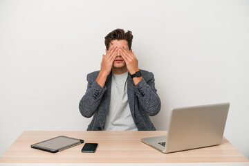 Young entrepreneur man working with a laptop isolated afraid covering eyes with hands.