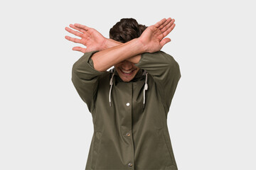 Young handsome caucasian man isolated on white background keeping two arms crossed, denial concept.