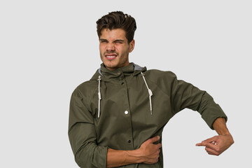 Young handsome caucasian man isolated on white background having a liver pain, stomach ache.